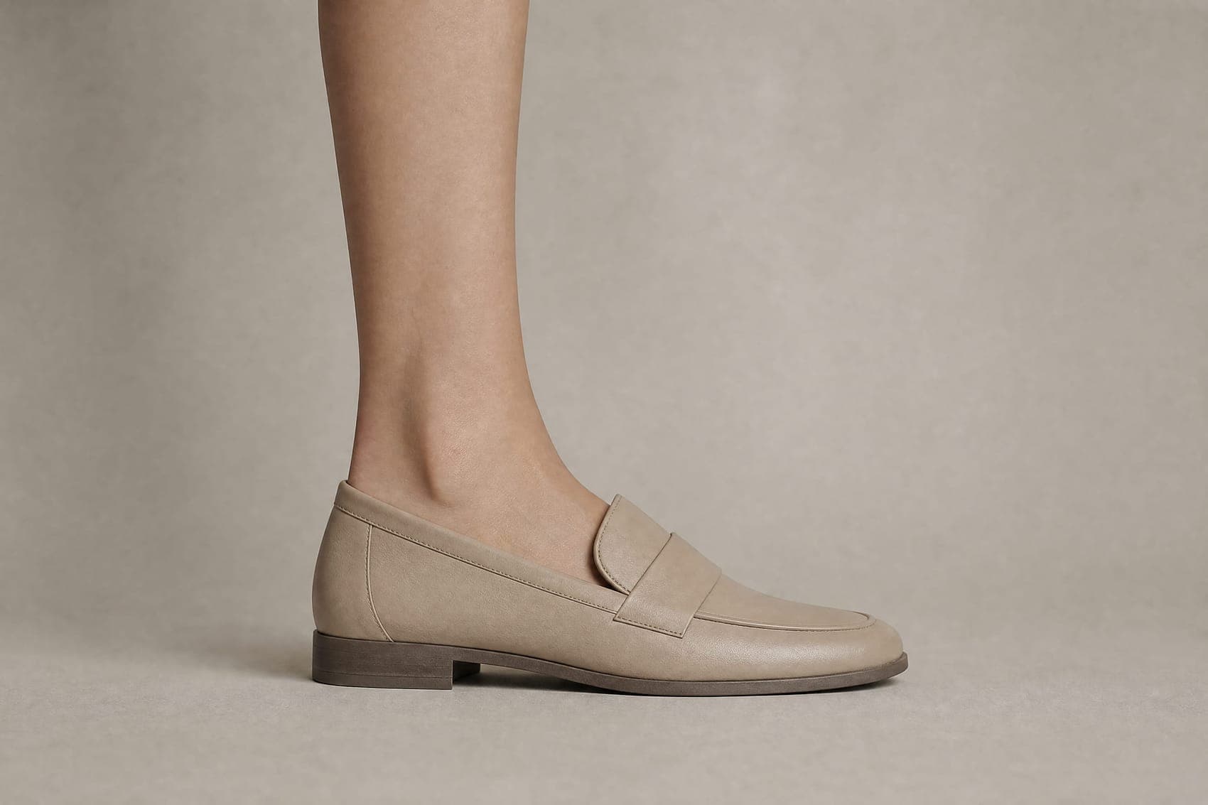 The same foot inside the same loafer. The ankle is bare and no sock is visible above the shoe.