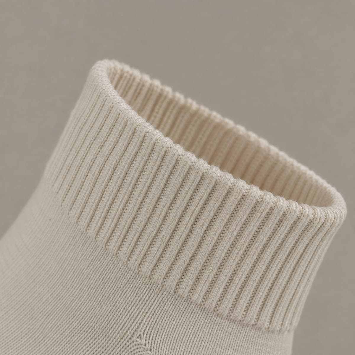 A deep elastic ribbed knitted band at the opening of a sock, with no silicone.